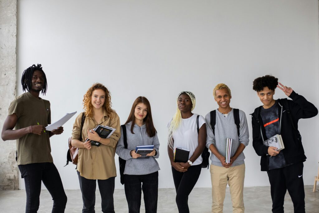 pexels-photo-6238130-6238130 Group of smiling multiracial classmates standing with books and backpacks and smiling widely at camera